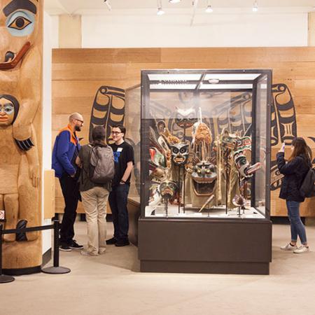 People inside of a museum exhibit surrounded by native art