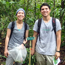 a woman and man stand in the jungle of south america while doing bat research