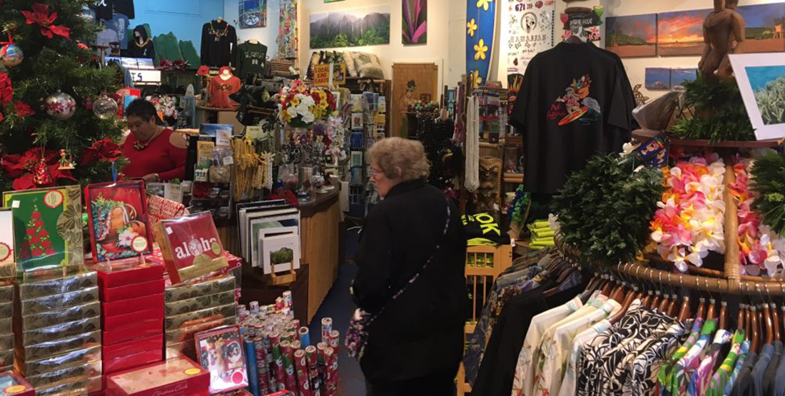 A woman shops in a store filled with cards, gift wrap and shirts