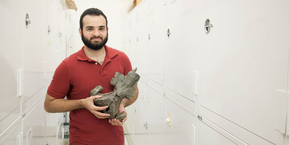 a man holds a baleen whale skull in the collection space