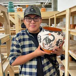 josiah concho holds up a piece of pottery