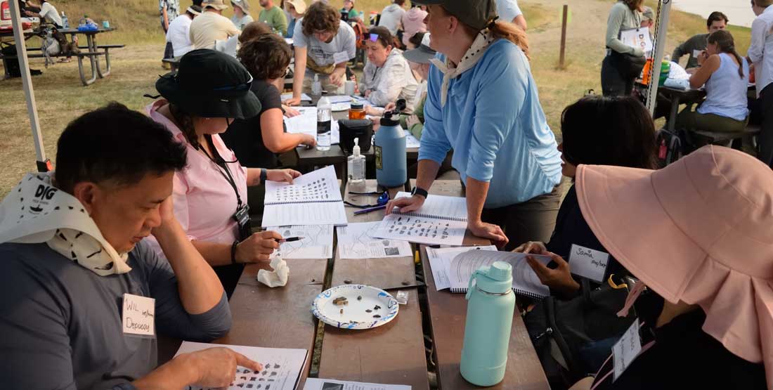    Teachers consult their guidebooks to properly identify a sampling of microfossils. 