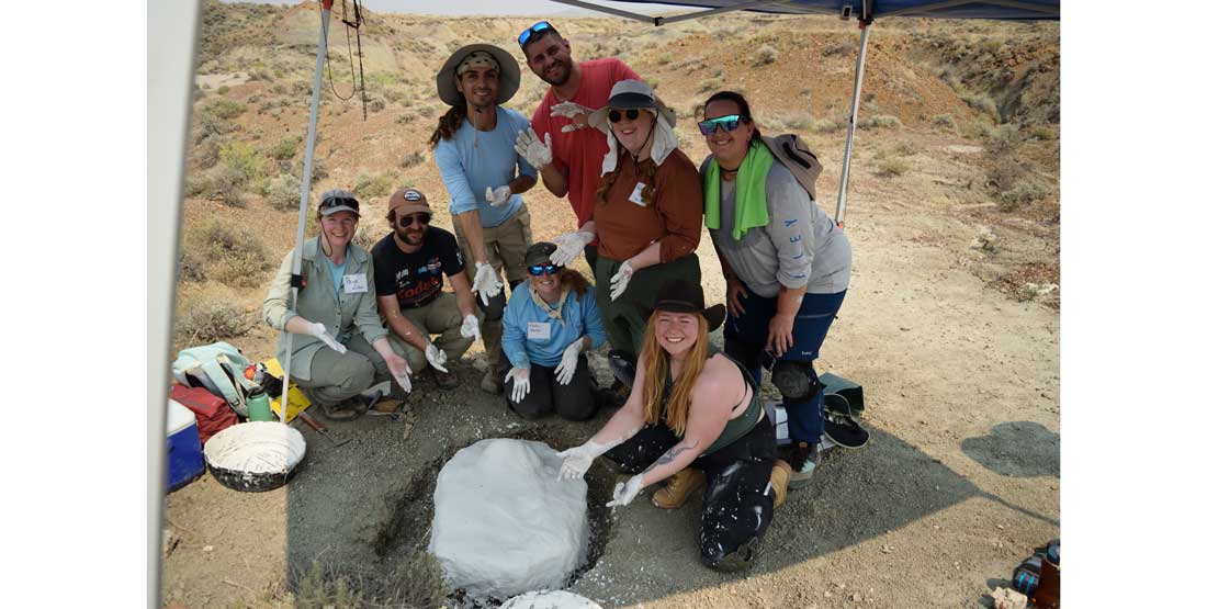 DIG instructors and participants complete the plaster jacket on a Triceratops limb bone. 