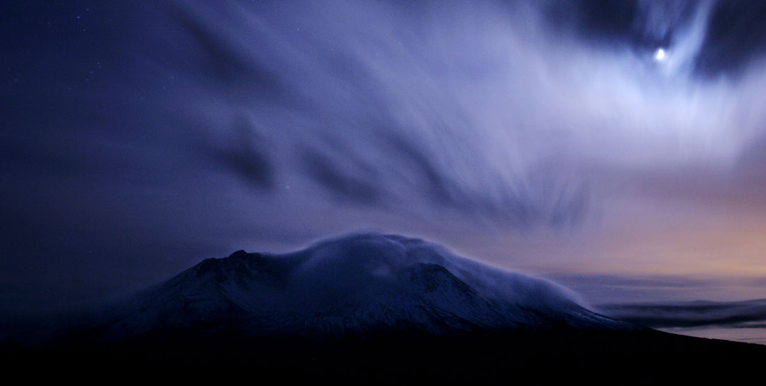 Mount St. Helens as seen from the Johnston Ridge Observatory at night, surrounded by clouds