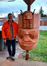 portrait of fred fulmer next to a large carving