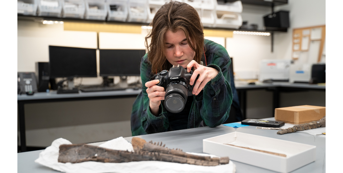 Rebecca Strauch takes a closer look at a fossil during her time at the Burke.