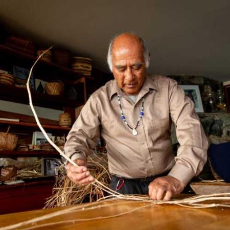 Carriere starts a basic weave with the split cedar limbs. Photo by Stuart Isett Carriere starts a basic weave with the split cedar limbs. Photo by Stuart Isett